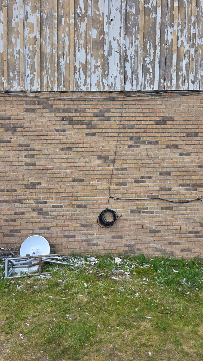 Tower sections, dish hardware, and cable stacked after removal.